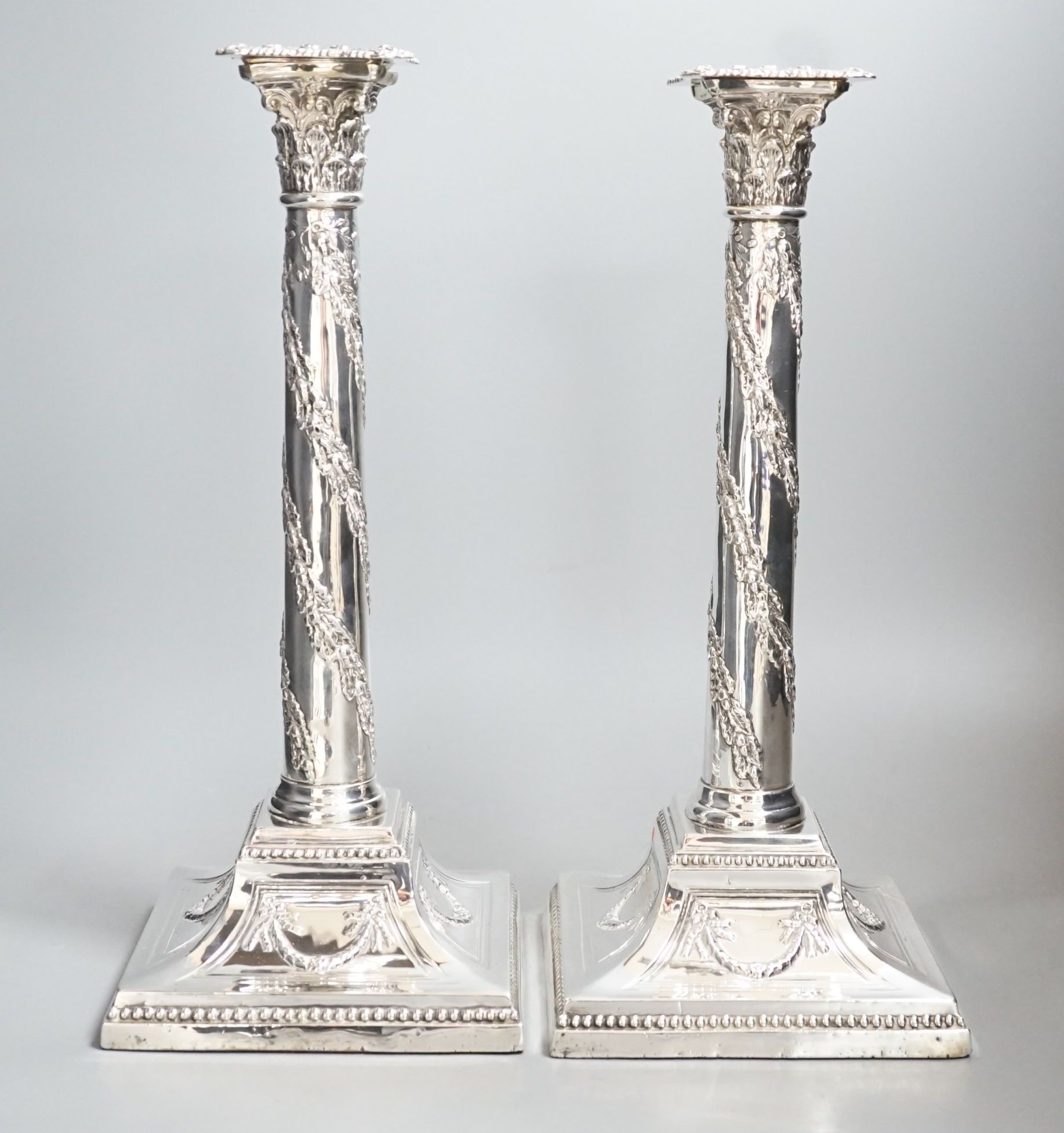 A pair of George V silver Corinthian column candlesticks, with spiral harebell columns, Ellis & Co, Birmingham, 1910, 34.2cm, weighted.